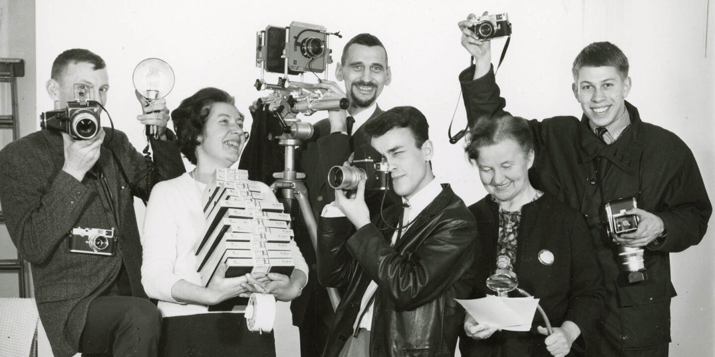 Personer framför kameran med egna kameror i händerna.