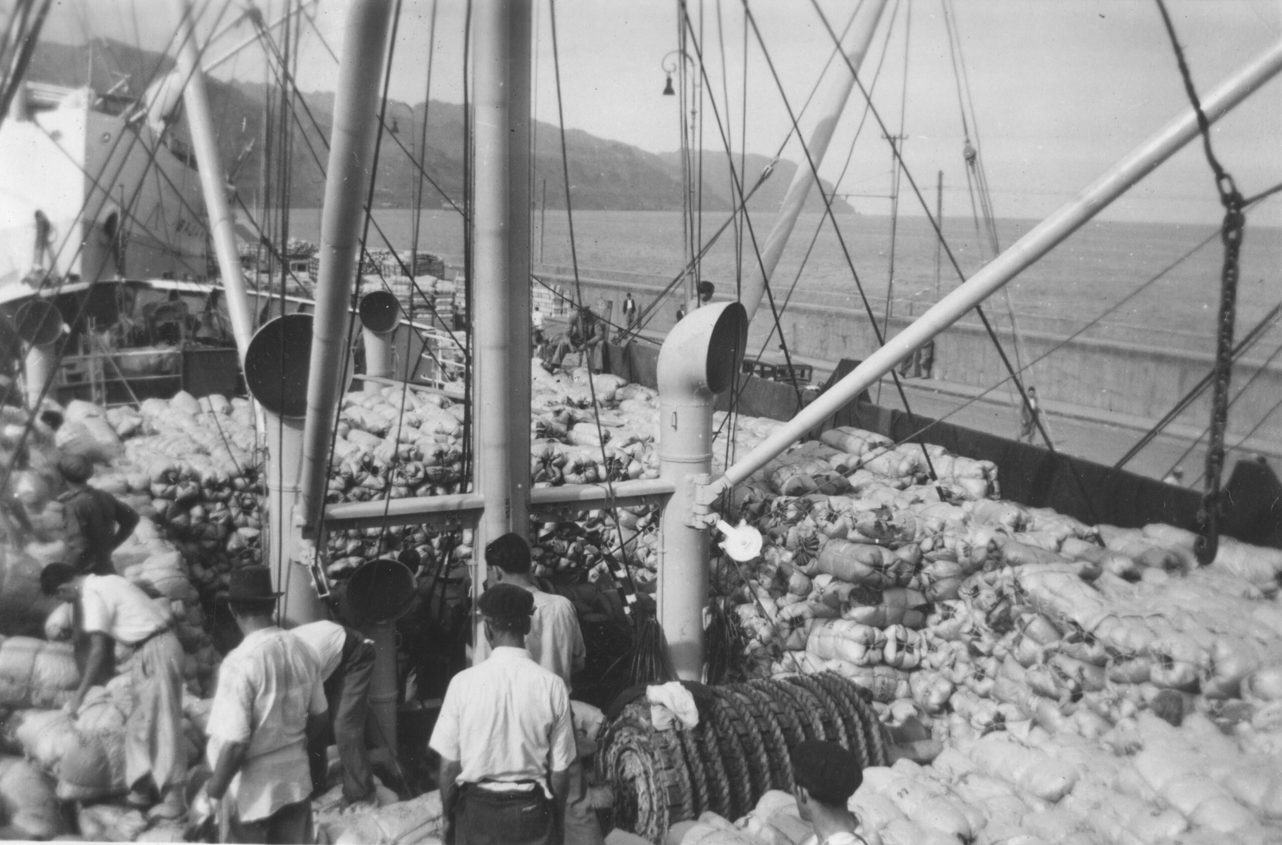 Sjömän lastar varor på handelsfartyg.